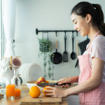 woman cutting oranges to make juice